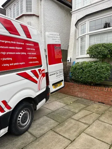 Greater London Drainage branded van on a residential London driveway, service list on the side panel